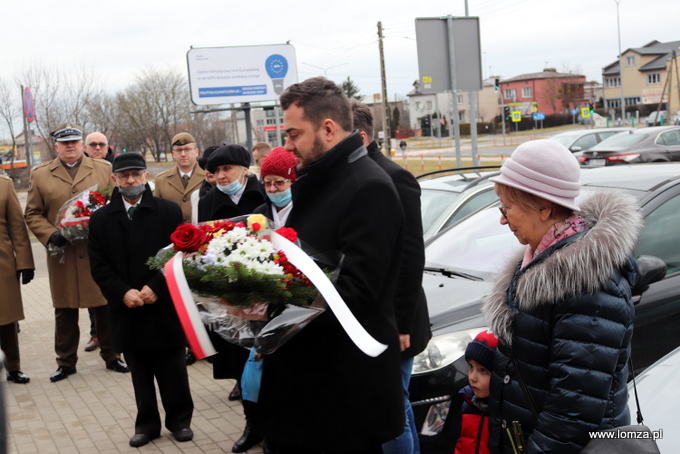 składanie kwiatów przed tablicą "Pamięci Zesłanych przez sowieckiego okupanta w latach 1940-1941 na nieludzką ziemię"