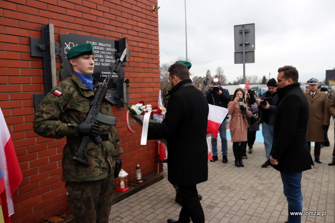 składanie kwiatów przed tablicą "Pamięci Zesłanych przez sowieckiego okupanta w latach 1940-1941 na nieludzką ziemię"