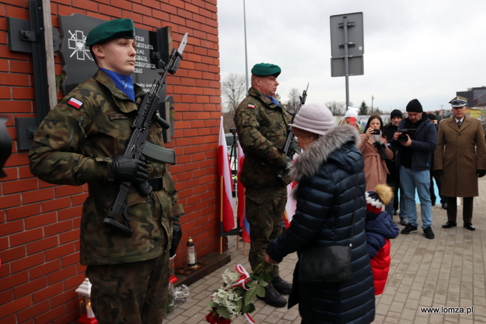 składanie kwiatów przed tablicą "Pamięci Zesłanych przez sowieckiego okupanta w latach 1940-1941 na nieludzką ziemię"