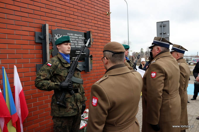 składanie kwiatów przed tablicą "Pamięci Zesłanych przez sowieckiego okupanta w latach 1940-1941 na nieludzką ziemię"
